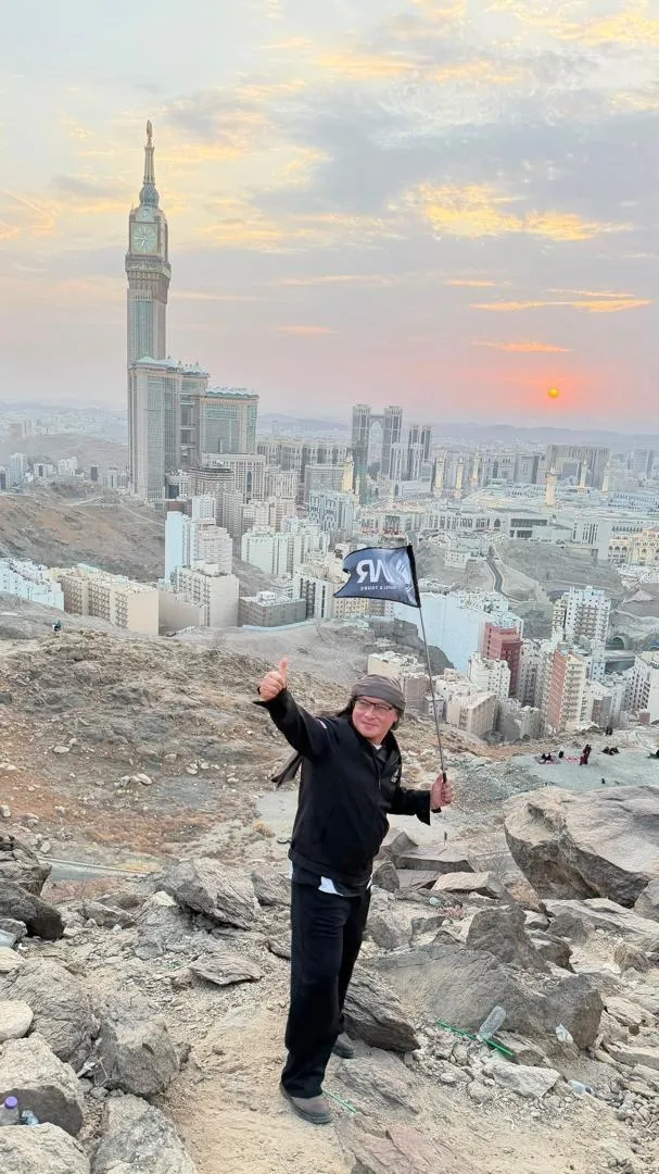Ustaz Abdul Razzaq mengibarkan bendera UAR di bukit menghadap Kota Makkah dan Menara Jam ketika senja